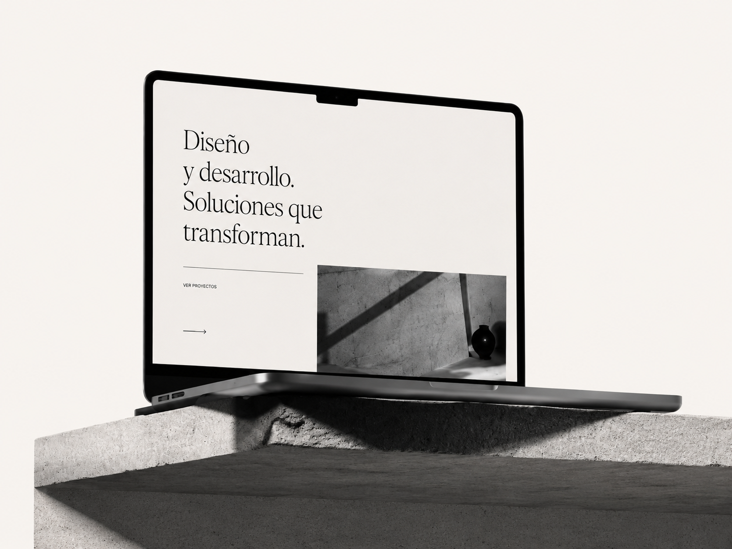 Portátil abierto sobre una mesa de hormigón mostrando una web de ejemplo